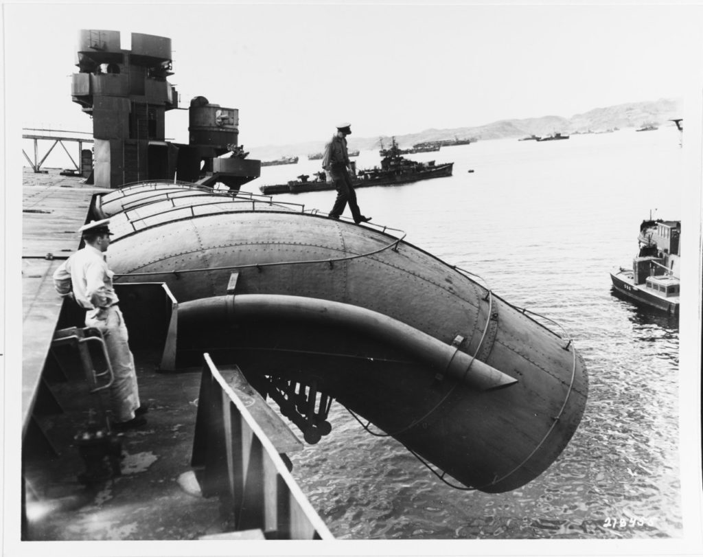 A U.S. Navy man walks out on one of Kasagi's downward curved smokestacks, at Sasebo, October 19, 1945.