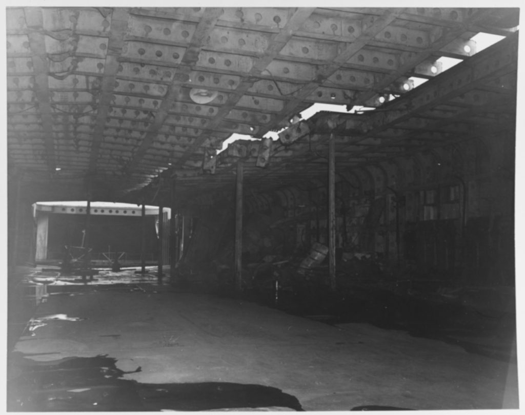 Damage to the flight deck of Ryuho at Kure, Japan, 9 October 1945. View in hangar deck looking forward, showing crack in flight deck.