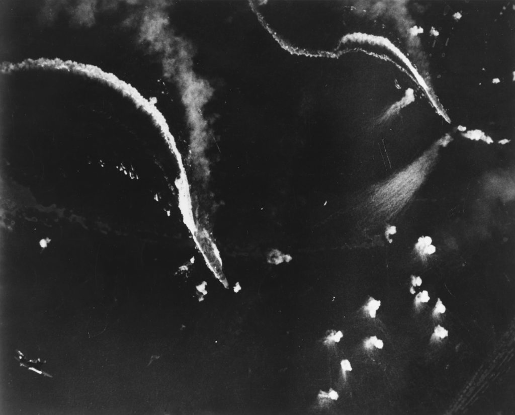 Zuikaku (left center) and (probably) Zuihō (right) under attack by U.S. Navy dive bombers during the Battle off Cape Engaño