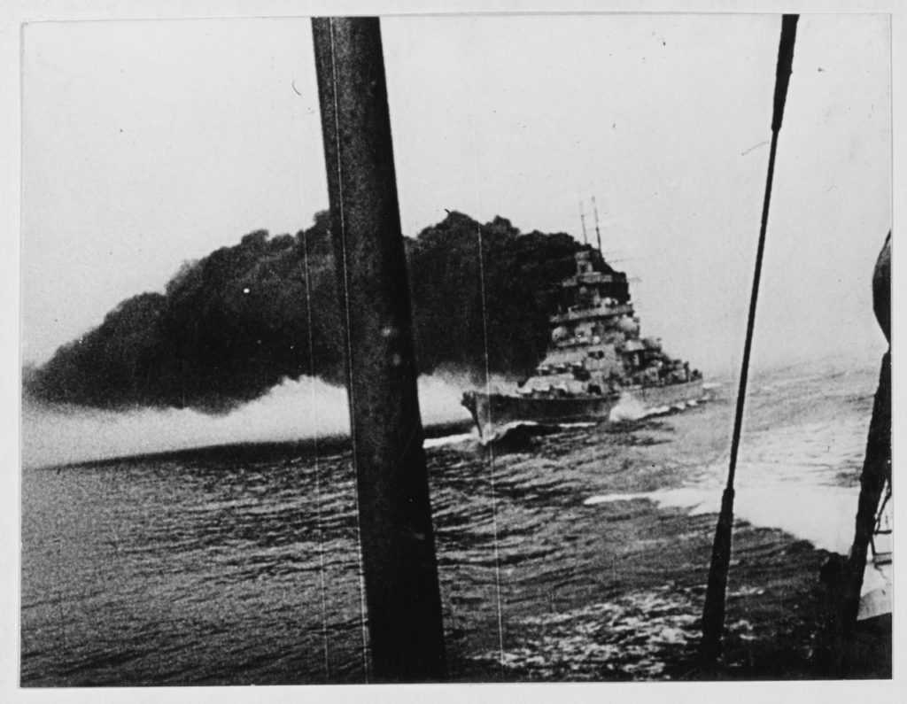 View taken circa 1940. The ship appears to be laying a smoke-screen