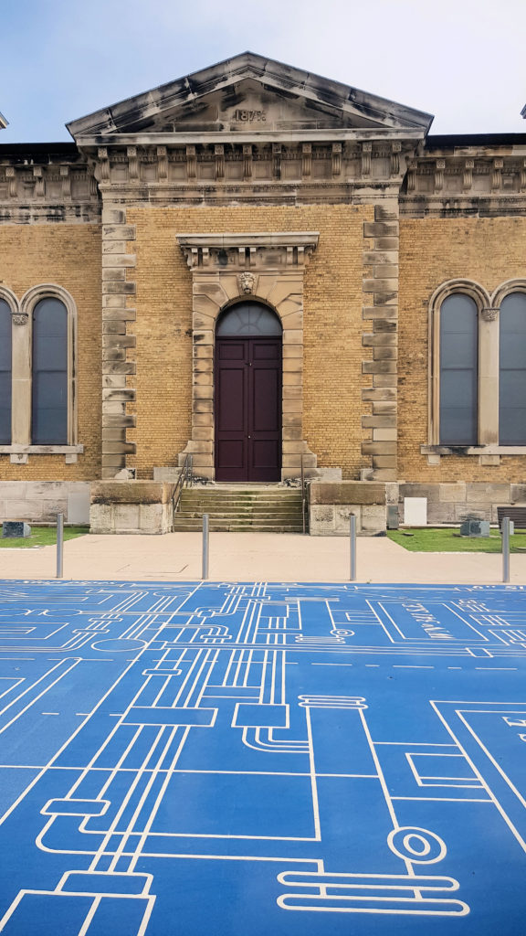 Front of the Building with the Blueprint Design in the Forecourt