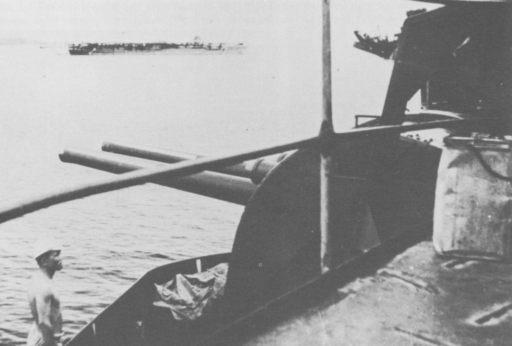 A crewman on Shokaku surveys damage to the ship, probably at Truk 1942 Zuikaku in background