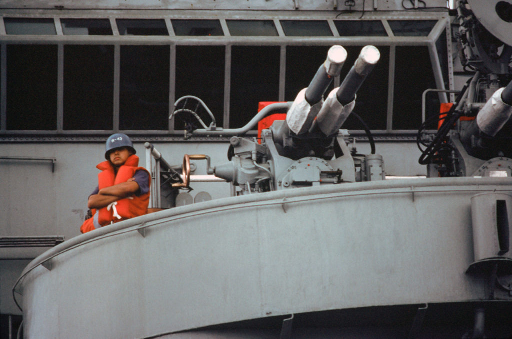 A gunner on Minas Gerais A-11 stands ready for an anti-aircraft defence exercise during Operation UNITAS XXV.