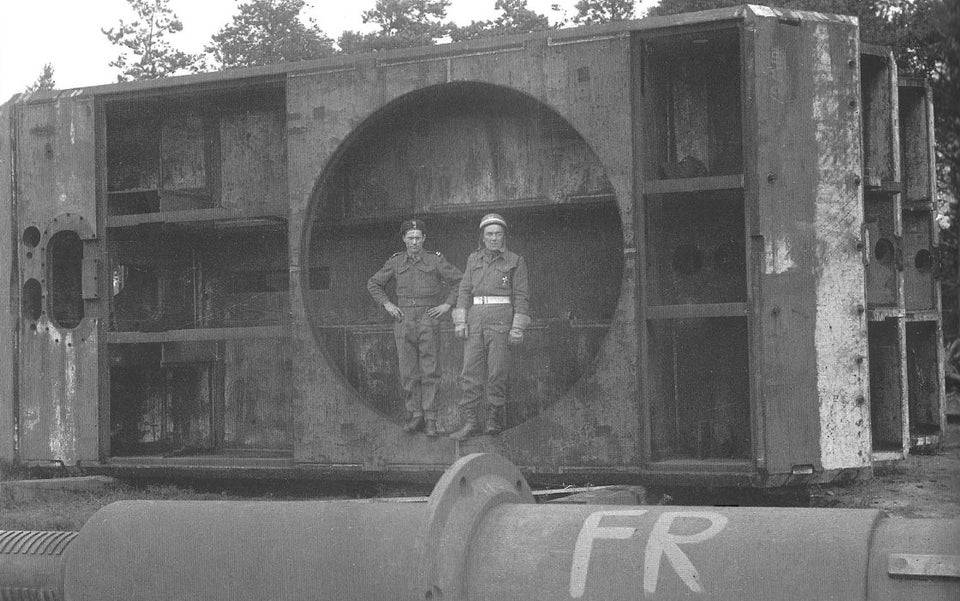 Two Polish soldiers pose inside the turret ring of a Maus hull at the Krupp proving grounds in Meppen, Germany