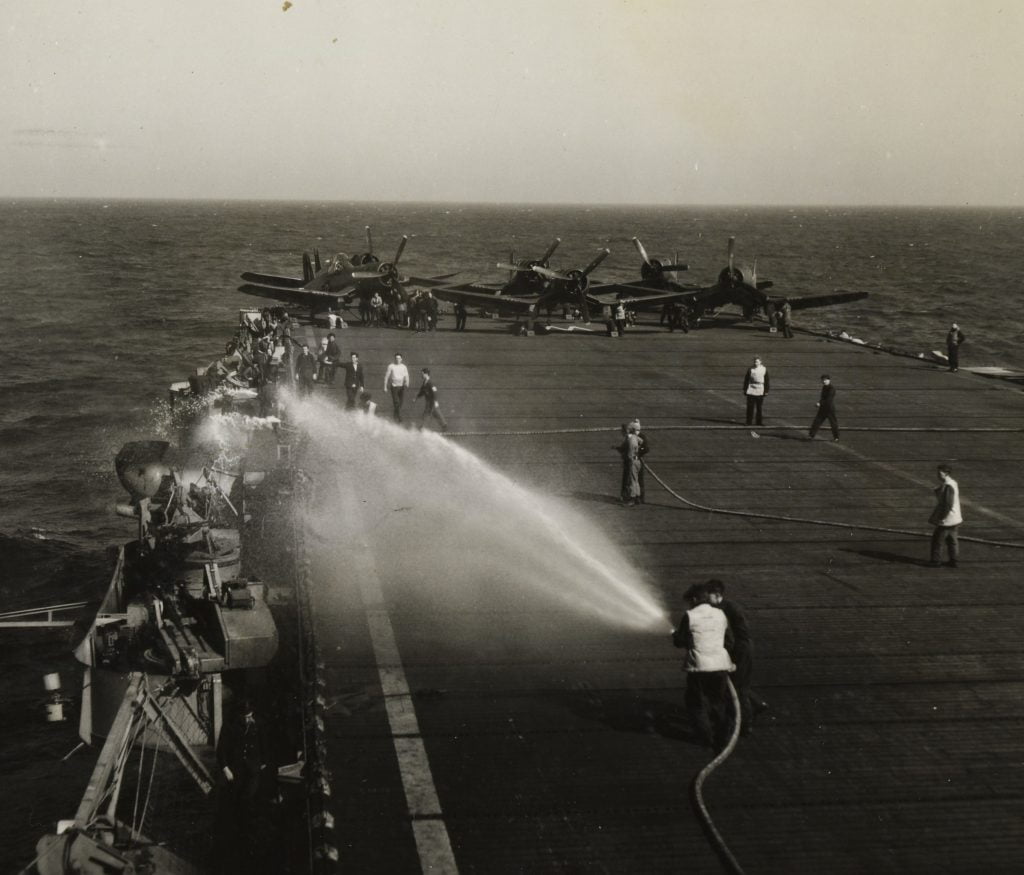 HMS Arbiter undergoing a fire drill. Note the Vought Corsair fighters on the flight deck