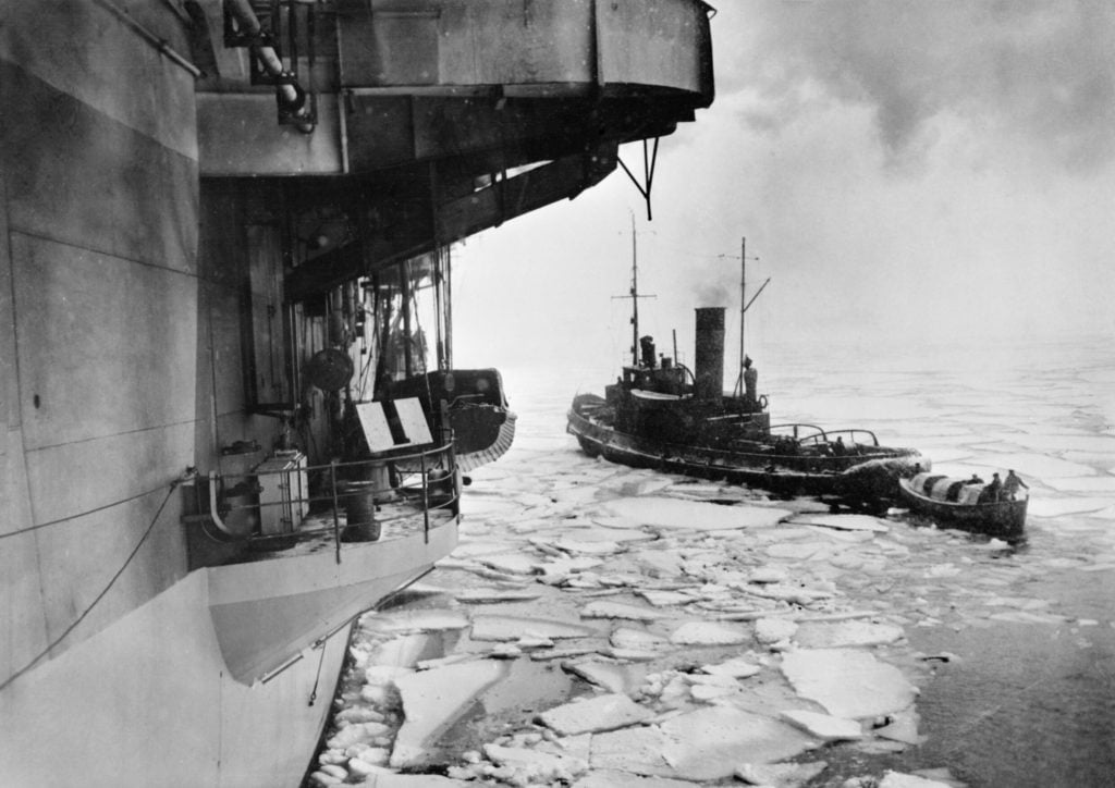 A motor-boat from HMS Trumpeter being assisted through the ice by a Russian Naval tug at Kola Inlet Mar 1945