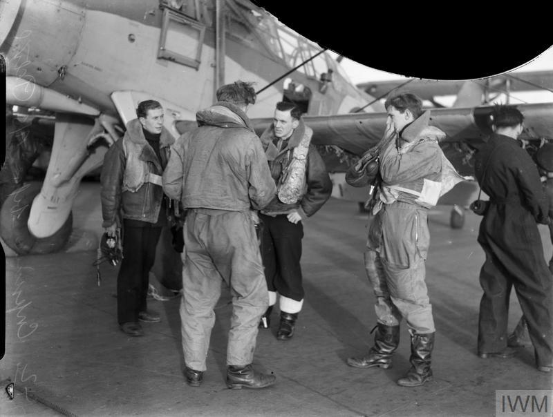 Fairey Albacore aircrew belonging to 820 Squadron, Fleet Air Arm in their flying gear having a conference on the flight deck of HMS Victorious