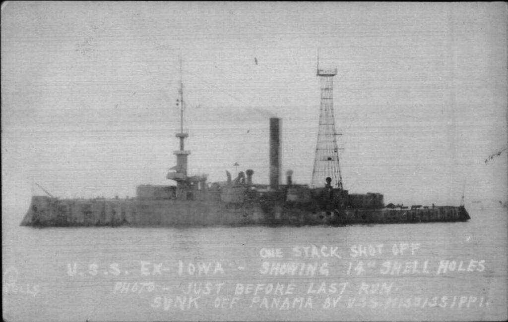 One stack shot off, USS ex-Iowa (BB-4) showing 14 inch shell holes. Just before last run, sunk off Panama by battleship Mississippi (BB-41)