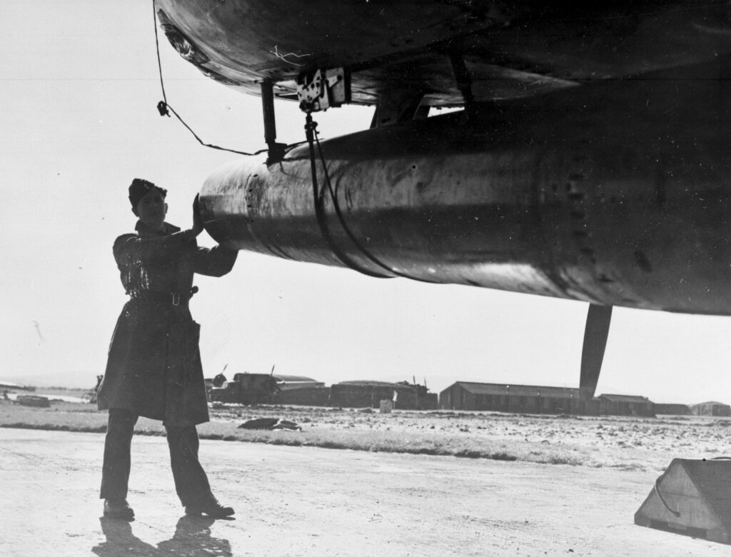 Airman checking the torpedo under a No. 489 Squadron Bristol Beaufighter