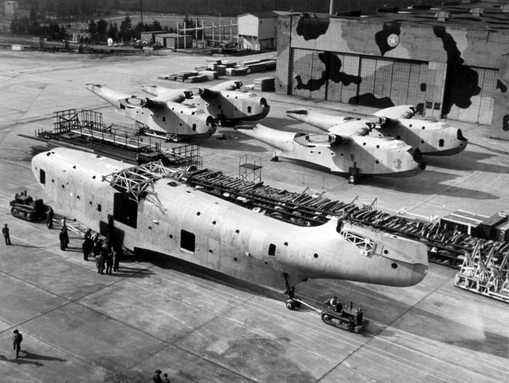 Martin XPB2M-1 Mars "The Old Lady" being towed out in front of four under-construction PBM Mariners