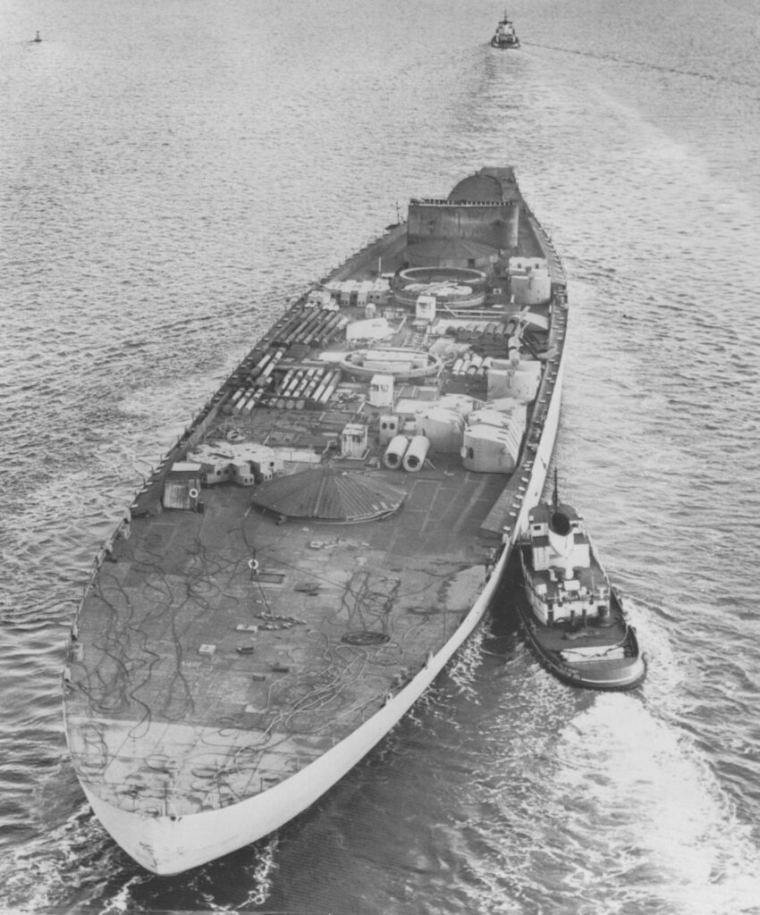 Hulk of the battleship Kentucky being towed to a salvage yard, October 1958