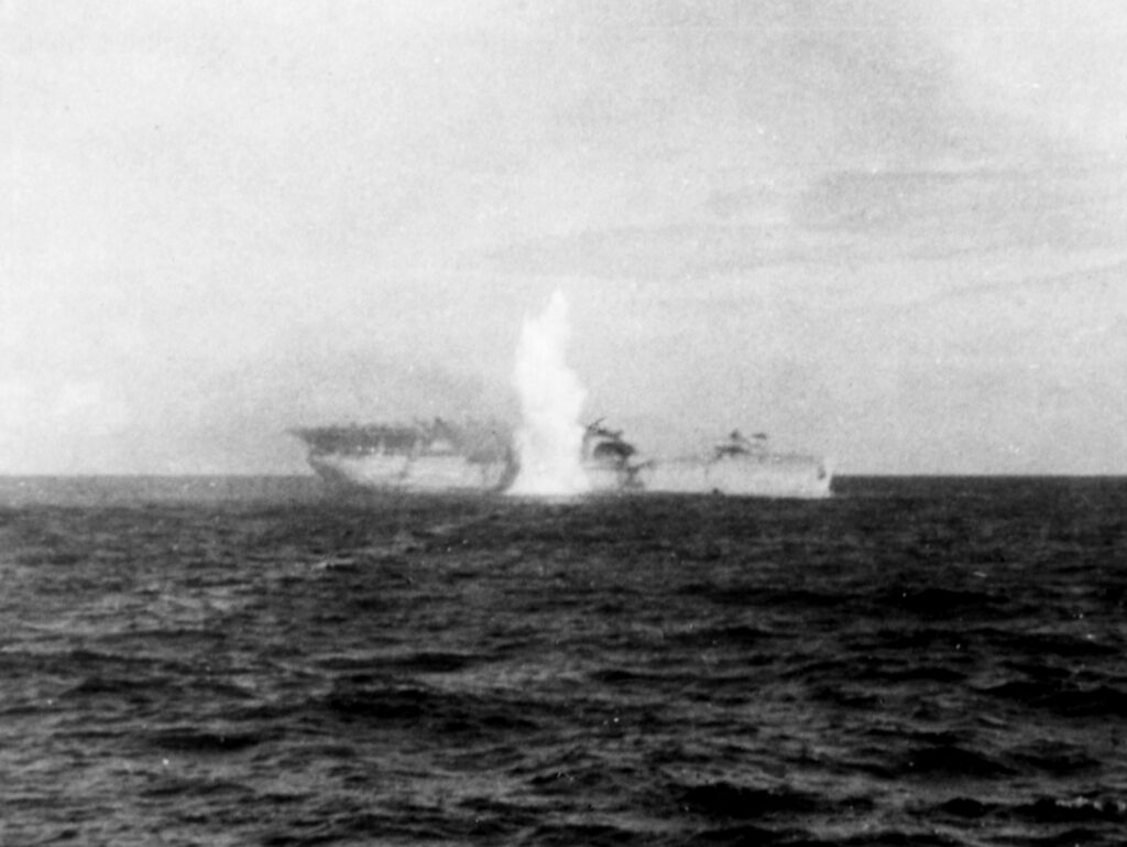 Starboard side close-up view of USS Langley AV-3 with torpedo exploding, fired by USS Whipple (DD-217), after being abandoned