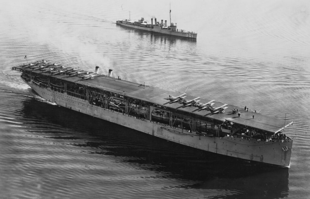 USS Langley CV-1 off San Diego, California, 1928, with Vought VE-7 aircraft on her flight deck. Escorted by USS Somers (DD-301)