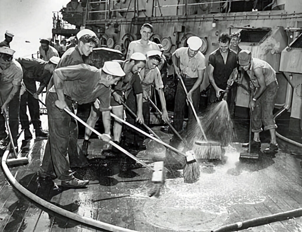 Sailors scrubbing down the deck of Prinz Eugen after an atomic bomb blast