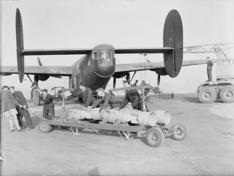 Armourers hauling a trolley of 500 lb bombs towards Liberator Mk II AL574 O of No 108 Squadron RAF at Fayid Egypt 1942