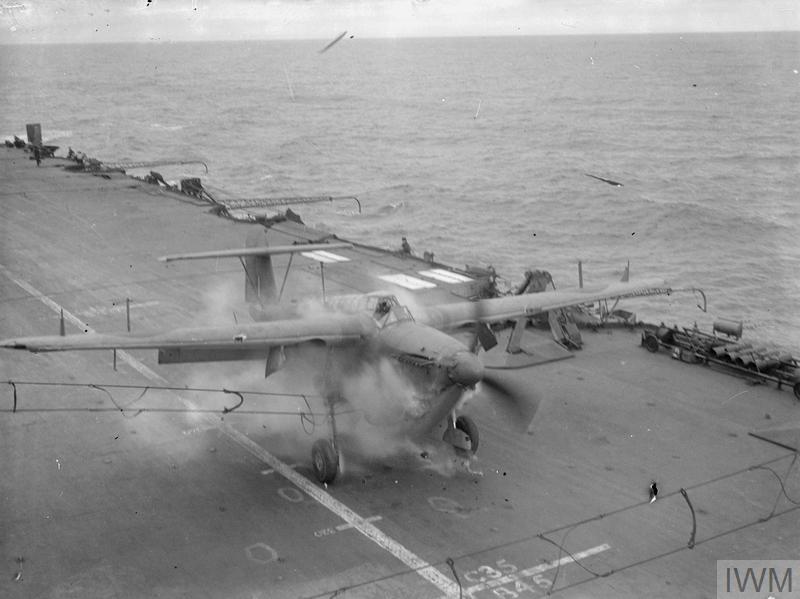 A Fairey Barracuda makes a bad landing on HMS Formidable and hits the crash barrier at speed. Bits of the propellor can be seen flying in the air.