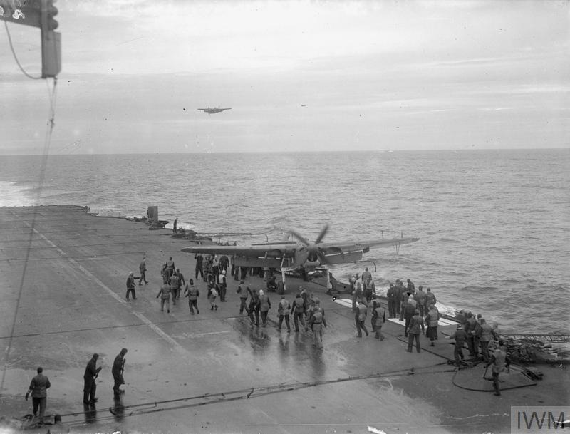 A Fairey Barracuda with its undercarriage damaged makes a landing on the extreme edge of HMS Formidable's deck. It was rescued by a crane.