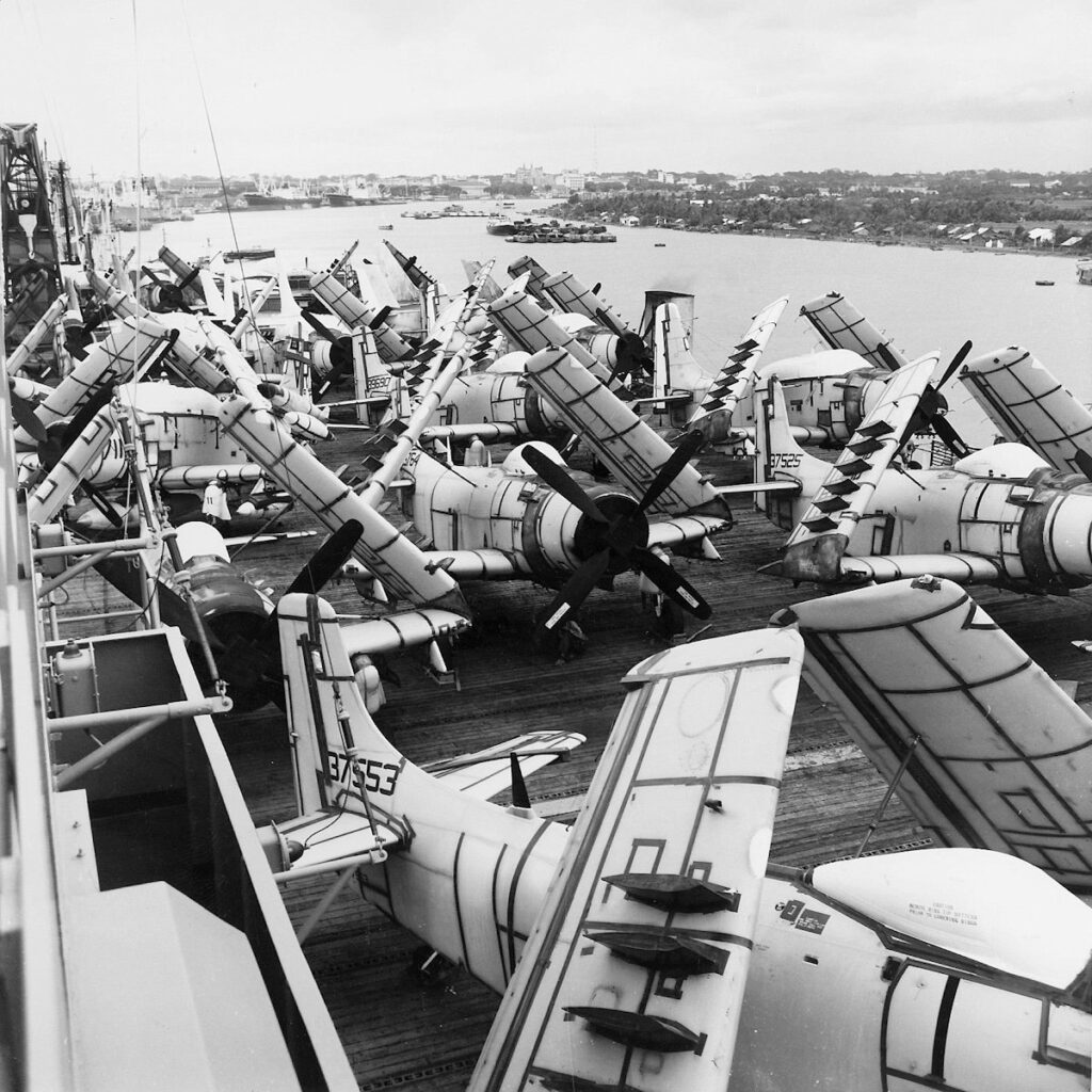 Douglas A-1 Skyraider aircraft on deck of the USNS Core (T-AKV-41) at Saigon, South Vietnam, circa 1965. Core delivered more than seventy warplanes