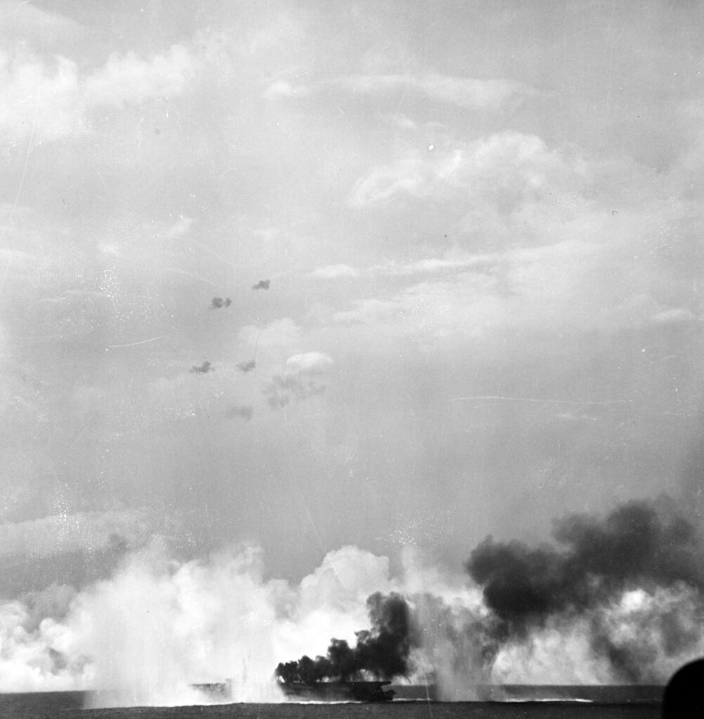 USS Gambier Bay (CVE-73) bracketed by Japanese shells while making smoke, during the battle off Samar, 25 October 1944