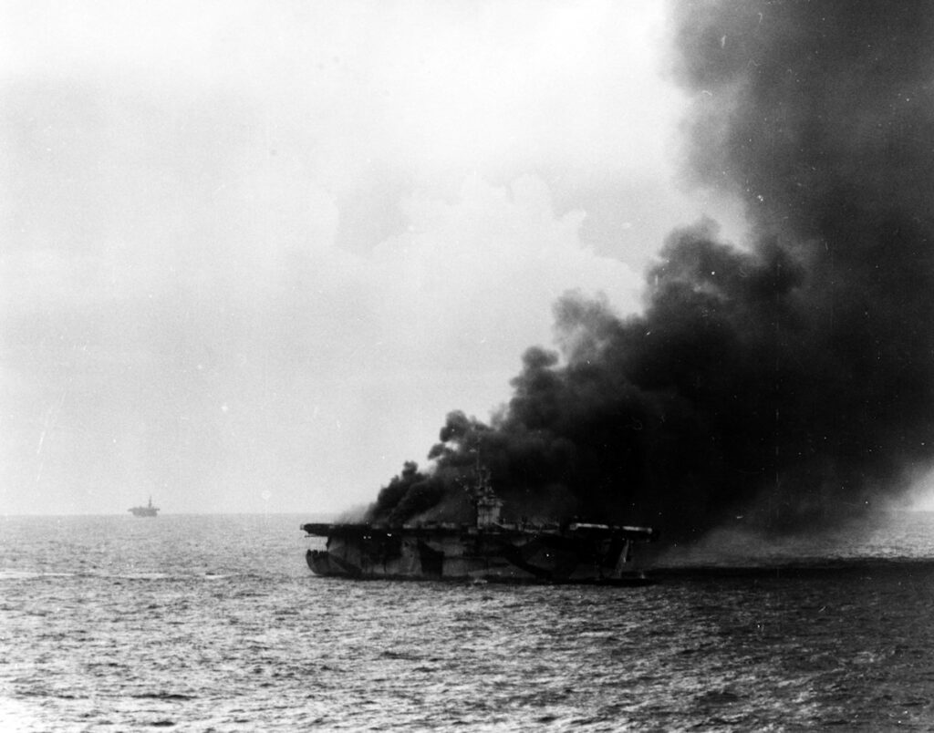 USS St. Lo (CVE-63) burns after being hit by a Kamikaze on 25 October 1944. taken from USS Kalinin Bay (CVE-68)