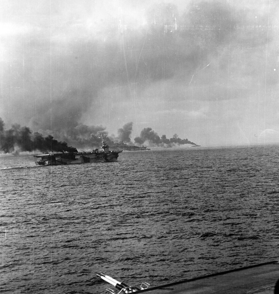 USS Gambier Bay (CVE-73) another escort carrier and two destroyer escorts making smoke. Photo from USS Kalinin Bay (CVE-68)