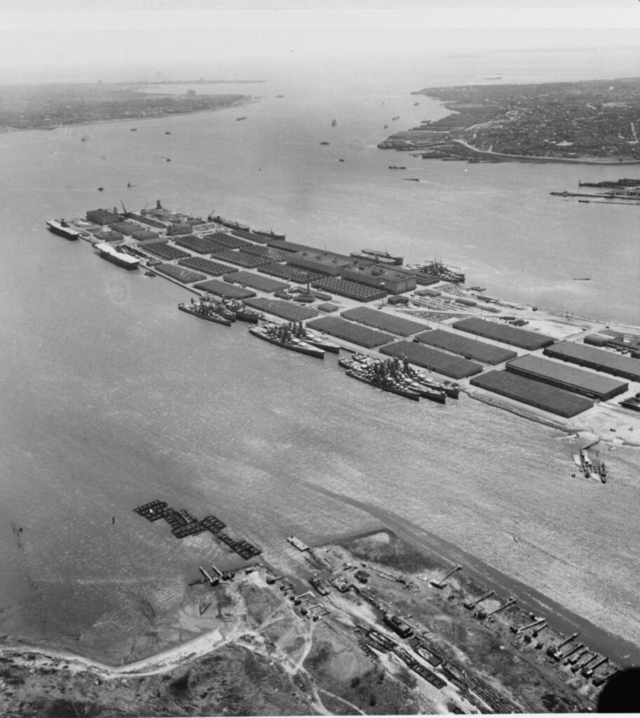 The two large ships at right on the near side of the peninsula are Alaska (CB-1) and Guam (CB-2). The next two ships astern are North Carolina (BB-55) and Washington (BB-56). Further astern are (from outboard to inboard) Fargo (CL-106), Albemarle (AV-5) and Wakefield (AP-21). The carriers Enterprise (CV-6) and Franklin (CV-13) are at the far left.