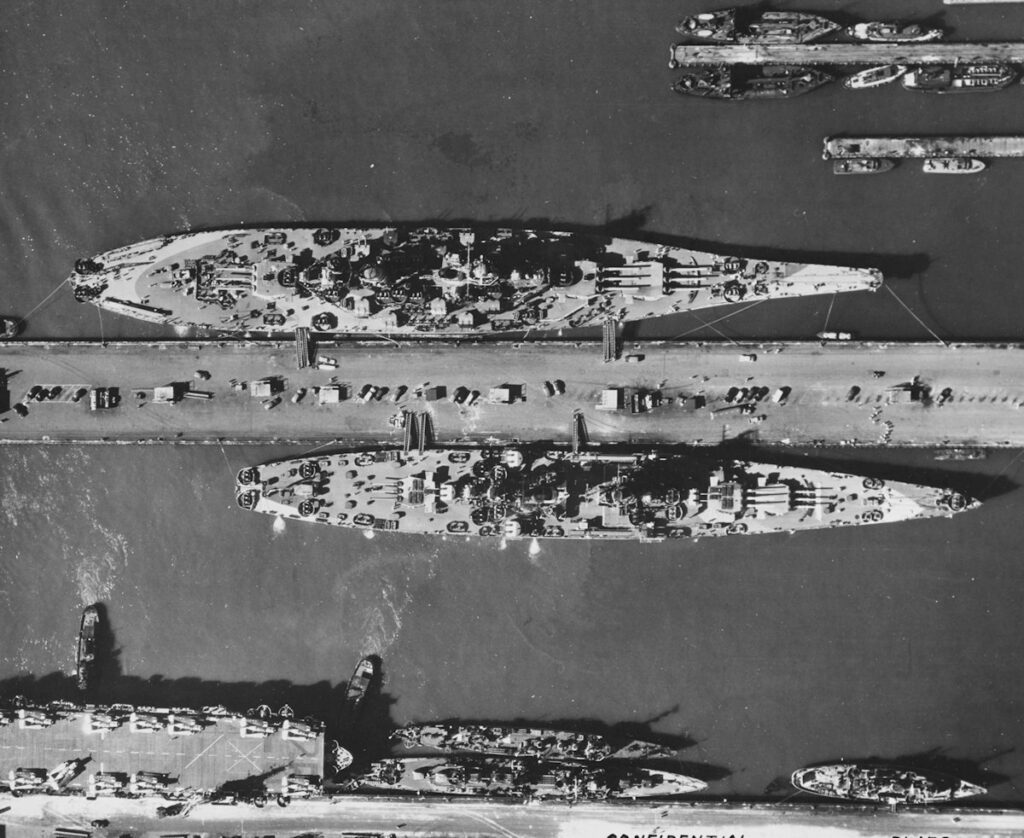 The largest ship is USS Missouri (BB-63), Alaska (CB-1), is on the other side of the pier August 1944