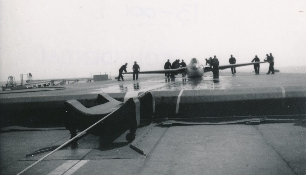 de Havilland Sea Vampire being maneuvered on the flexible flight deck on HMS Warrior