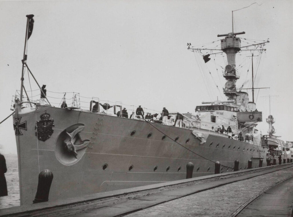 Emden wearing an Iron Cross on her bow to honor her First World War namesake