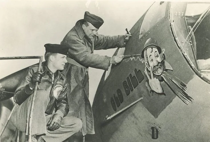 Boeing B-17F 42-29673 'Old Bill' having its nose art painted on by nose art was painted by Bruce Bairnsfather