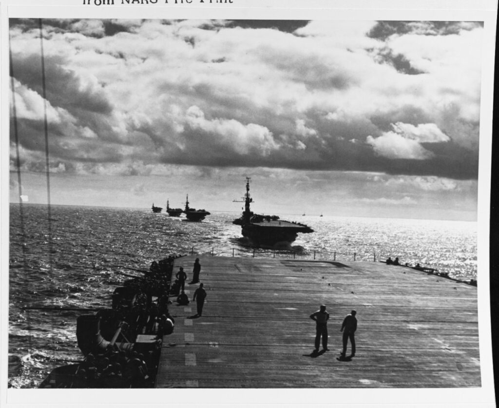 Practice division formation and maneuver exercises Hawaiian waters 13 January 1944. Photographed from USS Manilla Bay (CVE-61). Ships astern are Coral Sea (CVE-57), Corregidor (CVE-58), Natoma Bay (CVE-62), and Nassau (CVE-16)