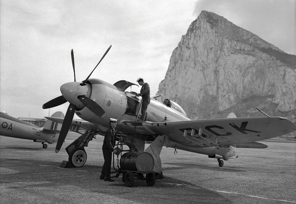 Hawker Sea Fury FB.11 VG-BCK from No. 803 Squadron, RCN 19th Carrier Air Group, being re-oiled, with the Rock of Gibraltar in the background, 7 Nov 1950